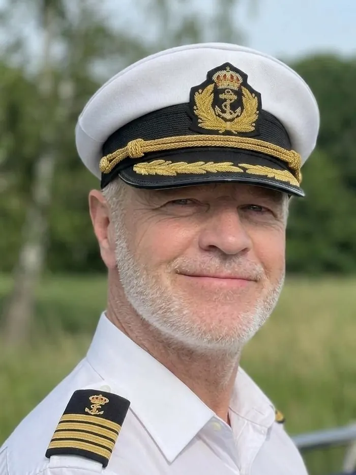 Kapten Kaj i vit uniform och kaptensmössa