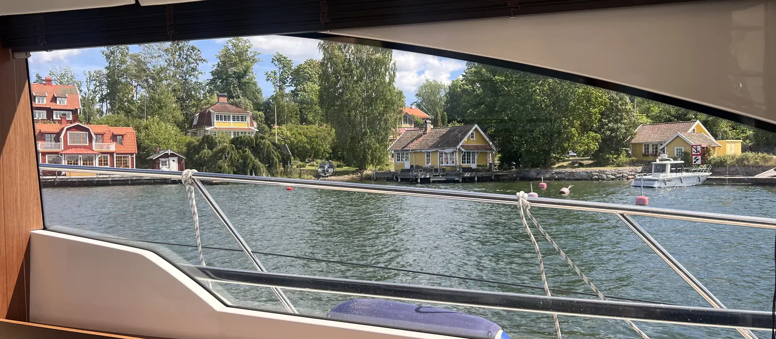 Röda skärgårdsstugor genom salongsfönstret